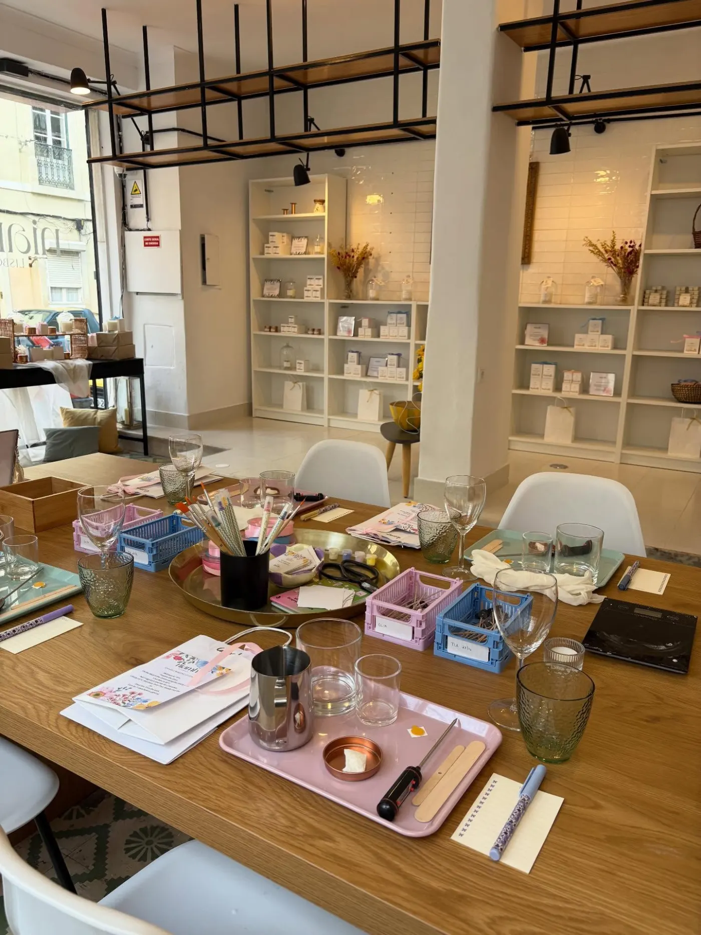 Niamh's studio set up for candle making, with a long table of wax, tools and labels in front of shelves of candles
